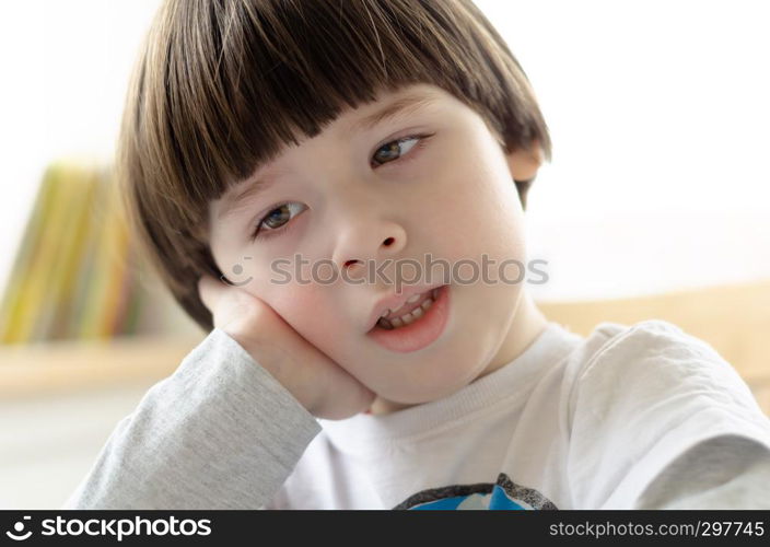 boy is sitting on chair and resting his head on his arm