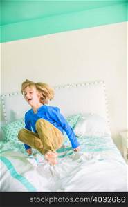 Boy jumping on bed smiling