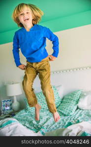 Boy jumping on bed smiling