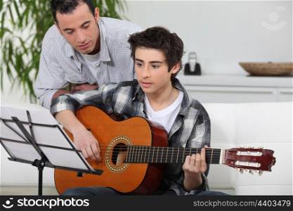Boy learning to play the guitar