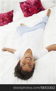 Boy Lying On Bed Wearing Pajamas