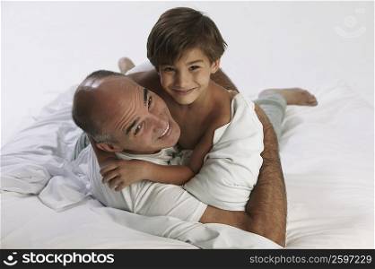 Boy lying on the bed with his father