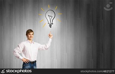 Boy of school age. Schoolboy pointing at light bulb with finger. Idea concept