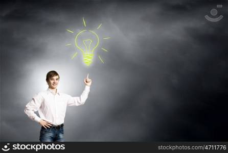 Boy of school age. Schoolboy pointing at light bulb with finger. Idea concept