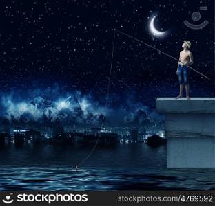 Boy of school age with fishing rod at night