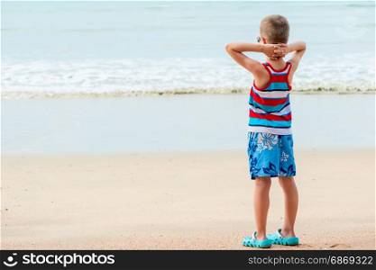 Boy on a sandy beach enjoying the sea on vacation