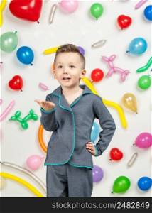 boy on a white background with colorful balloons. boy sending an air kiss on a white background with balloons in the shape of a heart. boy in the background of balls