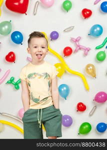 boy on a white background with colorful balloons. boy in a tank top and shorts on a white background with balloons in the shape of a heart. boy in the background of balls