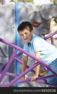 Boy On Climbing Frame In Park