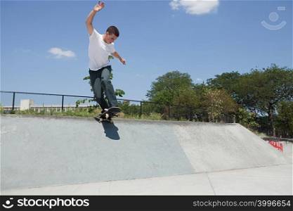 Boy on skateboard jumping off ramp