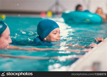 Boy on swimming class with instructor