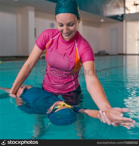 Boy on swimming class with instructor