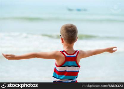 boy on the sea with outstretched hands in the hand rests