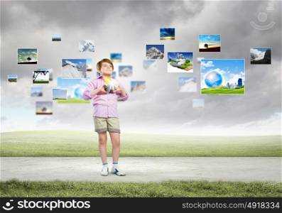 Boy photographer. Image of cute boy holding photo camera standing among photos