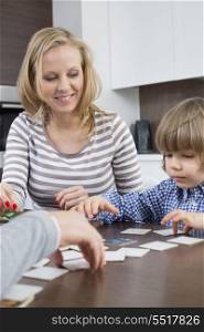 Boy playing cards with parents at home