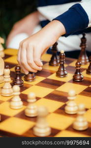 Boy playing chess at home. Sitting at the table and thinking hard.