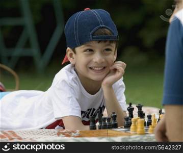 Boy playing chess at picnic