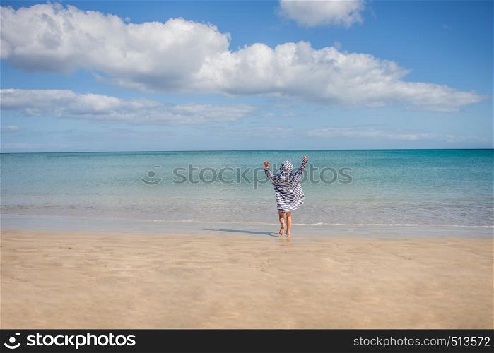 boy playing in a sea covered against sun burn