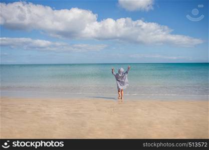 boy playing in a sea covered against sun burn