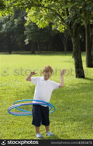 Boy playing with a plastic hoop in a park