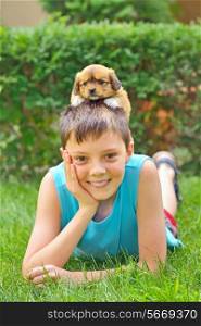 boy playing with a puppy in garden