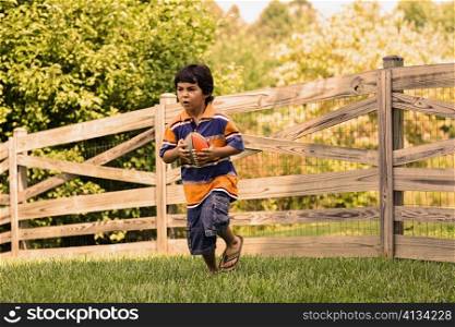 Boy playing with a rugby ball