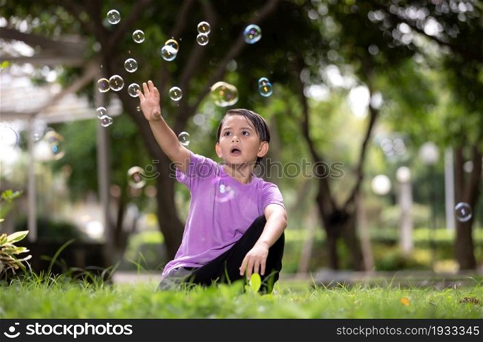 Boy Playing With Bubbles At Park