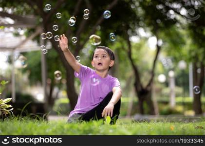 Boy Playing With Bubbles At Park