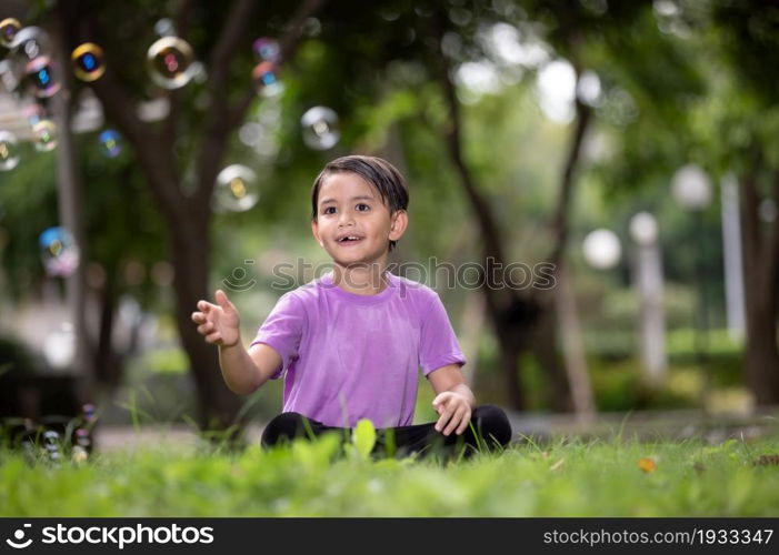 Boy Playing With Bubbles At Park