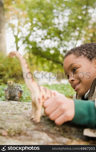 Boy playing with toy dinosaurs