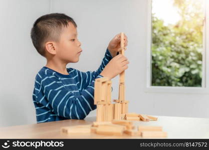 boy playing with wooden blocks at home