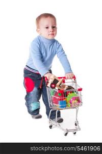 Boy plays with shopping trolley and toys, isolated on white