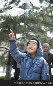 Boy pointing up with parents on the background
