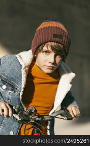 boy posing with his bike outside city