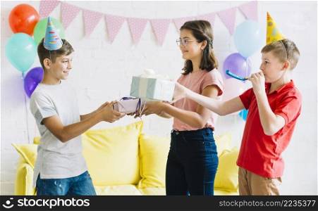 boy receiving birthday gift from his friends