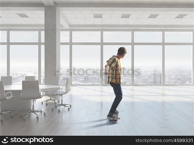Boy ride skateboard. Active guy riding skateboard in office interior. Mixed media