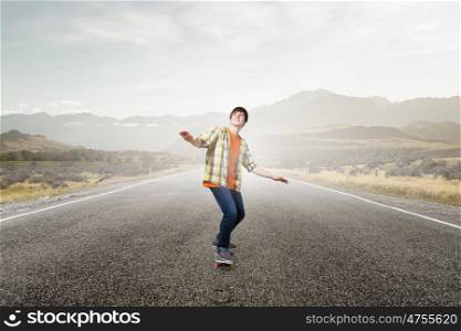Boy ride skateboard. Active guy riding skateboard on asphalt road