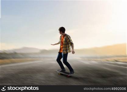 Boy ride skateboard. Active guy riding skateboard on asphalt road