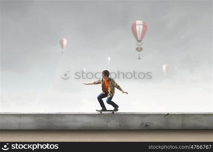 Boy ride skateboard. Active guy riding skateboard on building roof