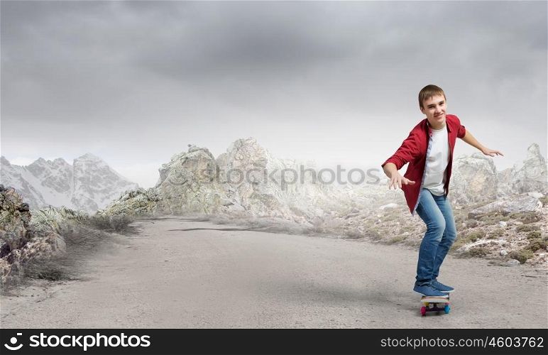 Boy ride skateboard. Active guy riding skateboard on road outdoor