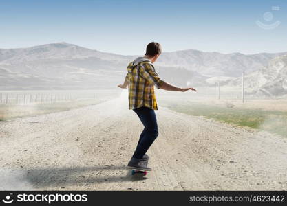 Boy ride skateboard. Active guy riding skateboard on road outdoor