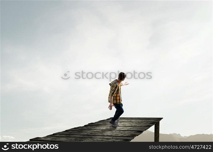Boy ride skateboard. Active guy riding skateboard on wooden pier