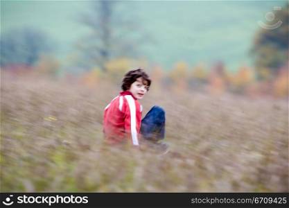 Boy riding a mountain board in a field