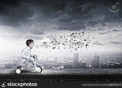 Boy riding bicycle. Little joyful cute boy riding tricycle on edge