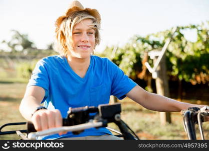 Boy riding farm truck in vineyard. Boy wearing hat and riding farm truck in vineyard