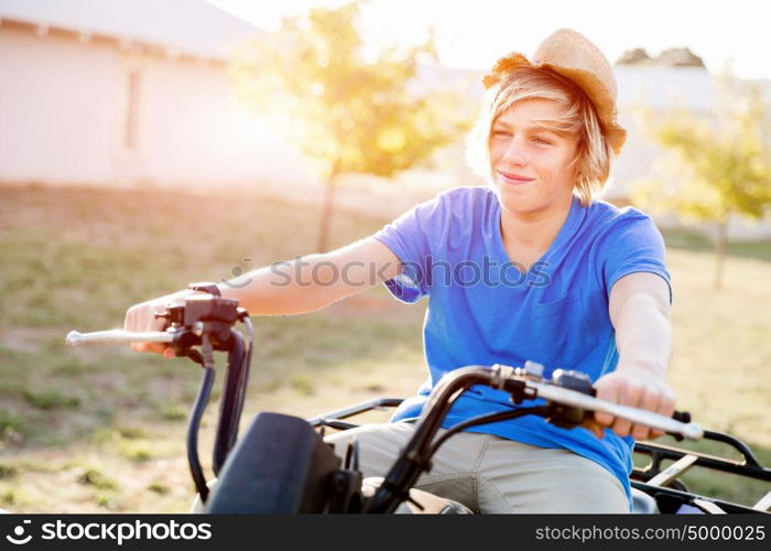 Boy riding farm truck in vineyard. Boy wearing hat and riding farm truck in vineyard