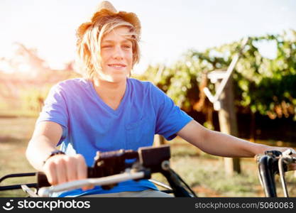 Boy riding farm truck in vineyard. Boy wearing hat and riding farm truck in vineyard