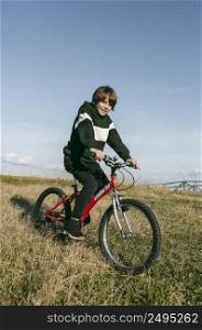 boy riding his bike grass outdoors