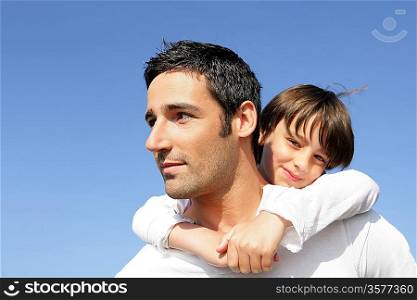 Boy riding piggy back on his father&acute;s back