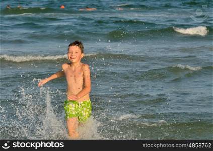 boy running through the waves at the beach